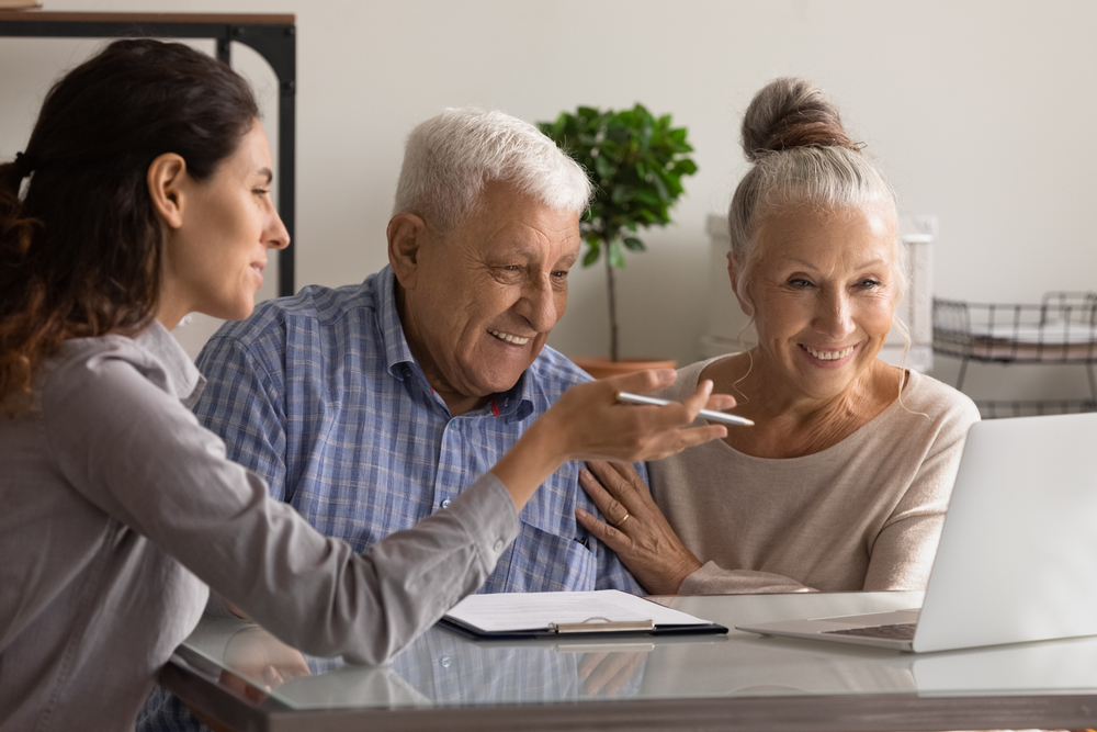 Happy senior couple meeting with a female consultant