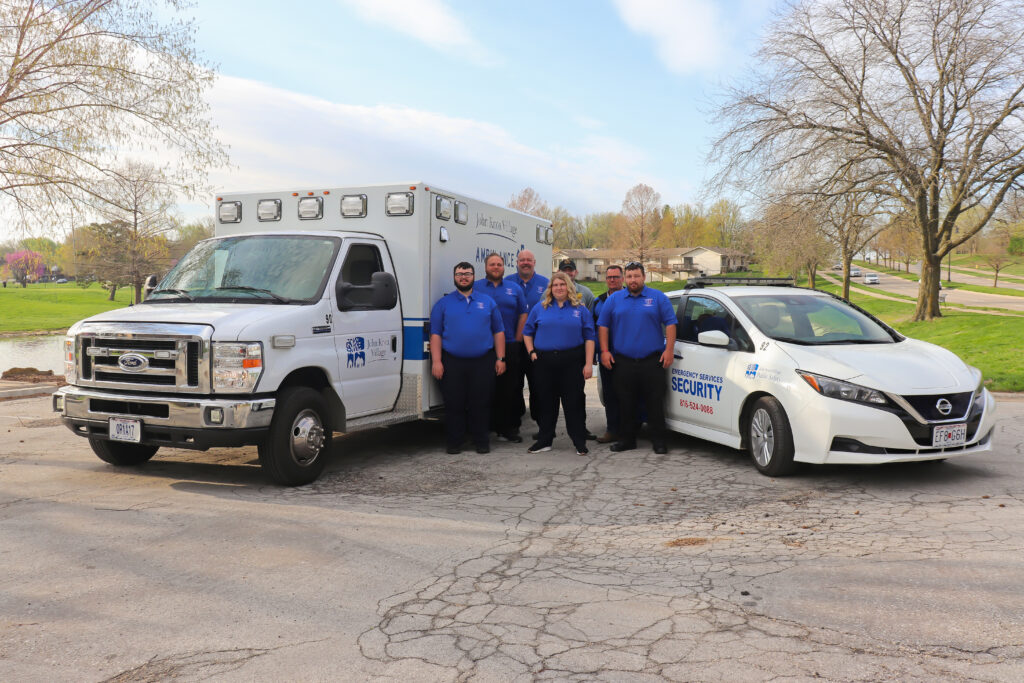 Emergency medical services team in front of ambulance and security car