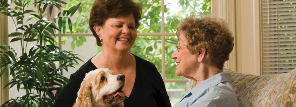 Two women sitting with a dog