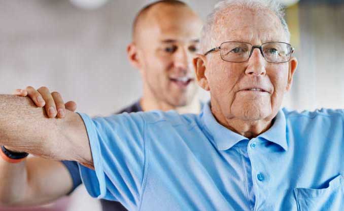 A rehabilitation specialists goes through exercises with a senior man