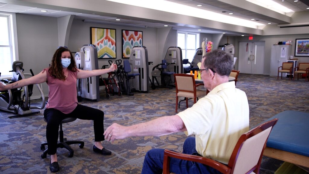 Physical therapist with resident during a PT session