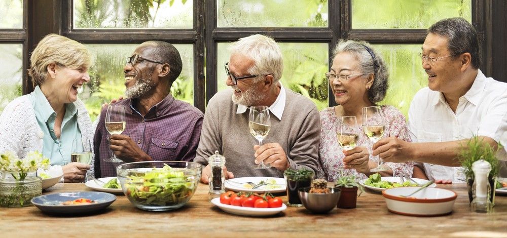 senior-friends-laughing-and-eating Seniors laughing and eating together