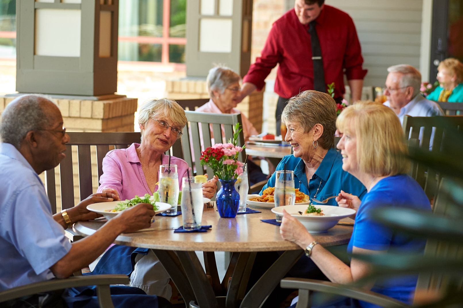 group of happy senior friends having lunch