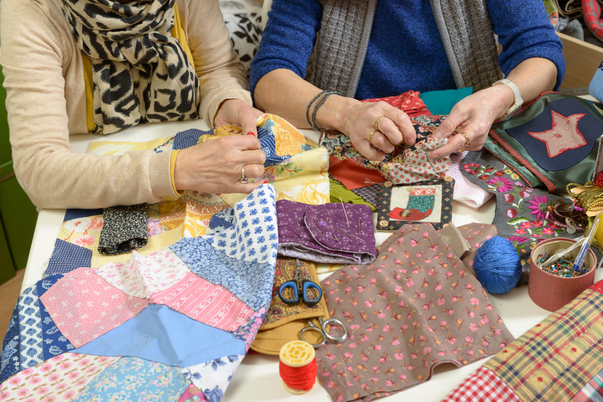 Two,Women,Working,On,Their,Patchwork,In,The,Workshop two elderly women quilting