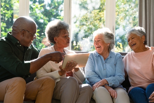 4 seniors sitting on couch laughing